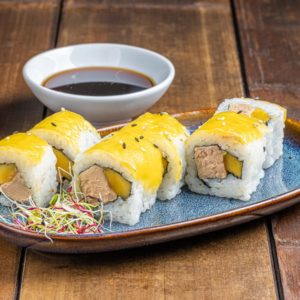 California roll garni de foie gras riche et onctueux, accompagné de tranches de mangue juteuse et sucrée, présenté de manière élégante pour une combinaison exquise.