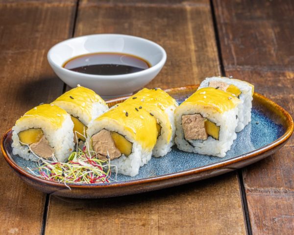 California-roll-foie-gras-et-mangue California roll garni de foie gras riche et onctueux, accompagné de tranches de mangue juteuse et sucrée, présenté de manière élégante pour une combinaison exquise.