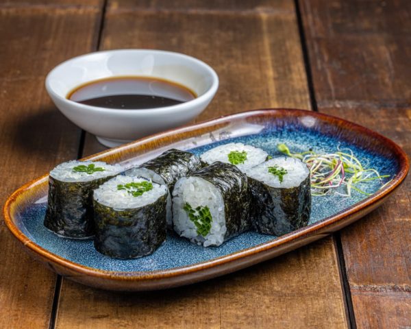 Maki soigneusement roulé, garni de crème cheese onctueuse et parsemé de ciboulette fraîche, offrant une combinaison crémeuse et herbacée pour une dégustation savoureuse et gourmande.