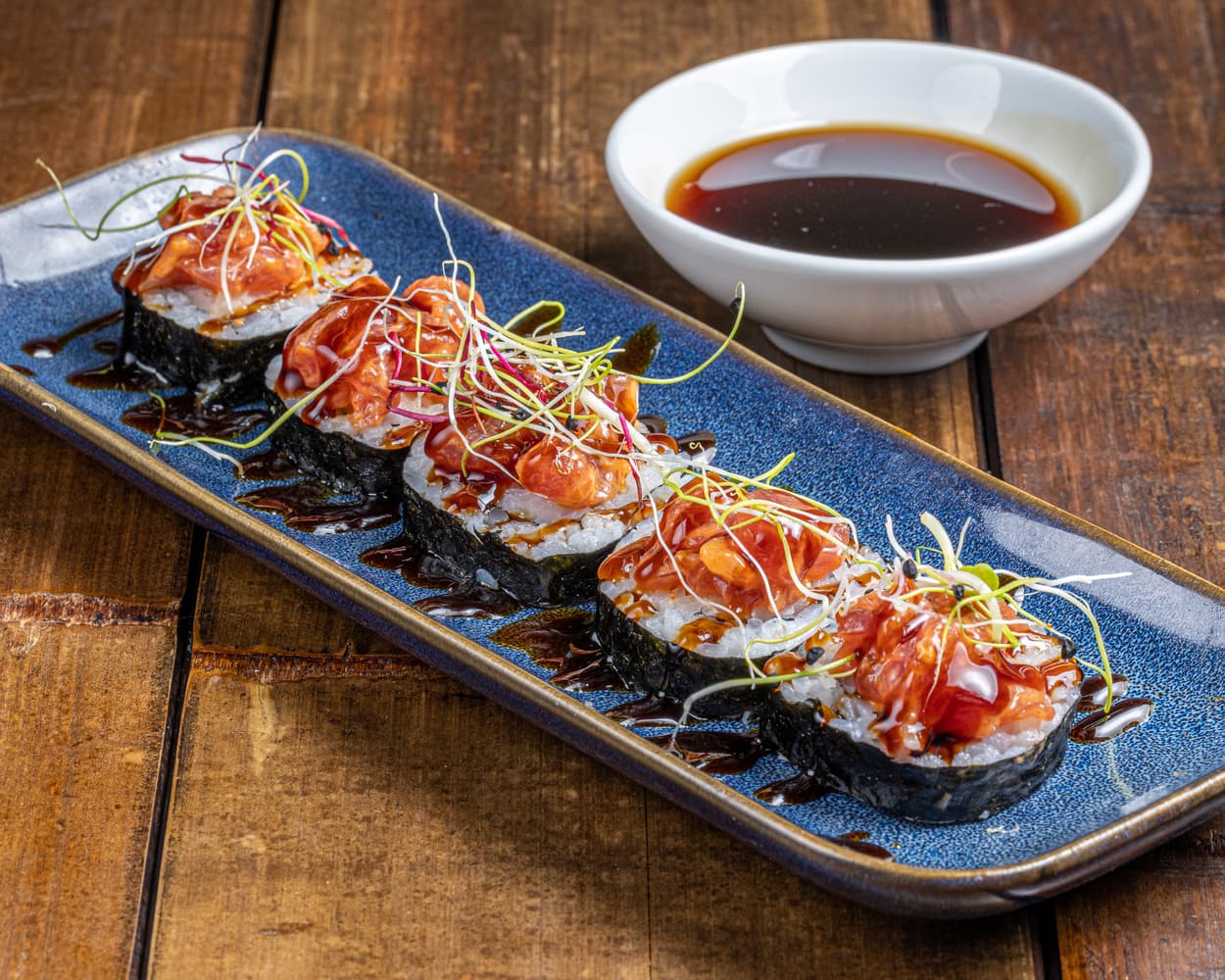 Maki lumineux à la teinte orange, garni de saumon frais et enveloppé d'une fine couche de riz vinaigré.