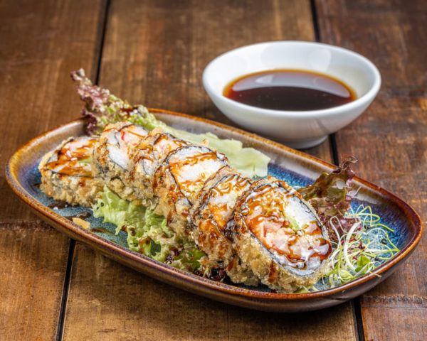 Maki Phily de 6 pièces, garni de saumon fumé, avocat crémeux, surimi savoureux et perles de tobiko, présenté de manière élégante pour une combinaison riche en saveurs.