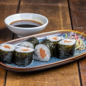 Maki délicatement roulé, garni de saumon frais et tendre, présenté de manière élégante pour une saveur authentique et riche.