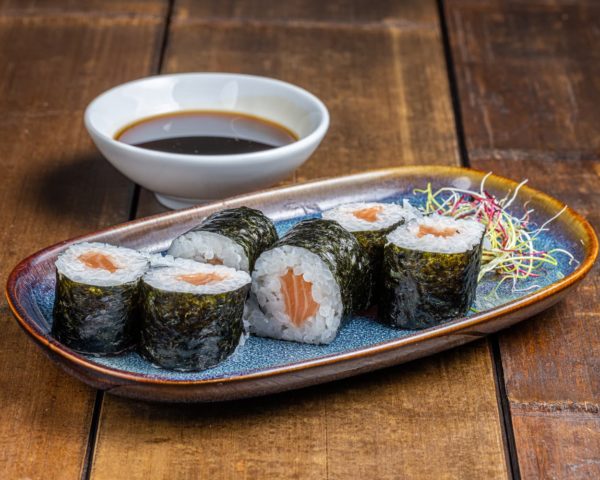 Maki-saumon Maki délicatement roulé, garni de saumon frais et tendre, présenté de manière élégante pour une saveur authentique et riche.