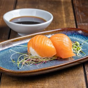 Nigiri délicatement façonné, garni d'une tranche de saumon frais et tendre, offrant une saveur marine authentique sur une base de riz vinaigré.