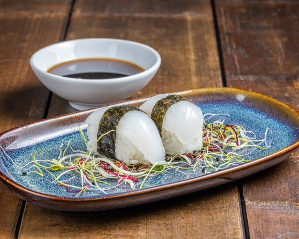 Nigiri-seiche Nigiri soigneusement façonné, couronné d'une tranche de seiche fraîche et translucide, reposant sur un lit de riz vinaigré.
