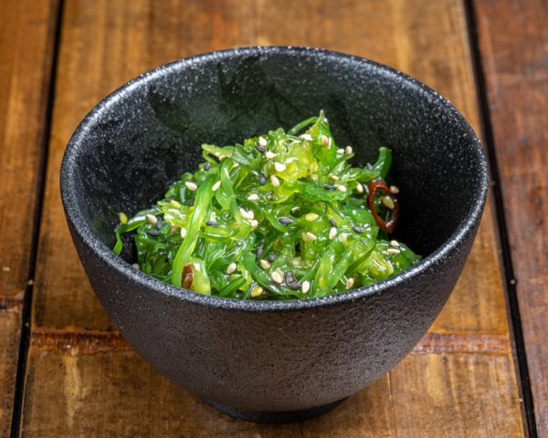 Salade d'algue wakame présentée dans un bol noir.