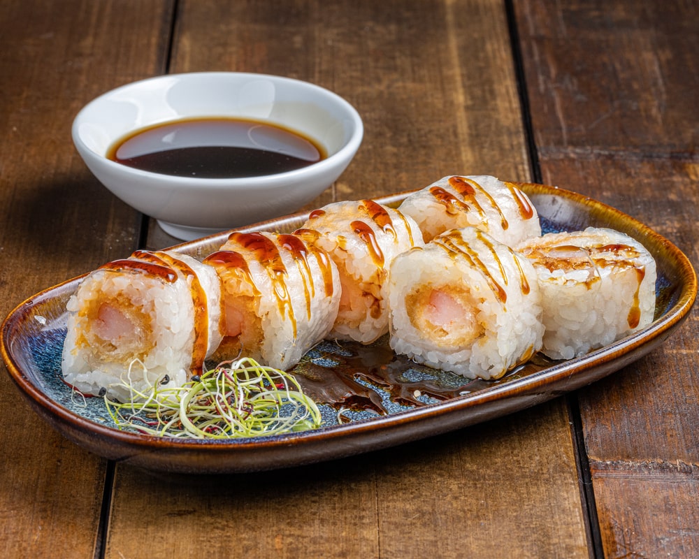 Spring maki roulé avec crevettes tempura croustillantes, enveloppé dans une fine tranche de concombre.