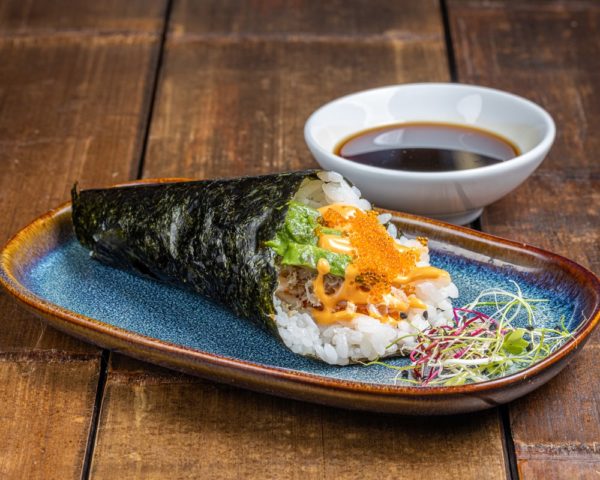 Temaki-chaire-de-crabe Temaki en forme de cône garni de chair de crabe fraîche, enveloppé dans une feuille de nori.