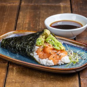 Temaki conique garni de saumon frais et d'avocat tranché, enveloppé dans une feuille de nori croustillante.