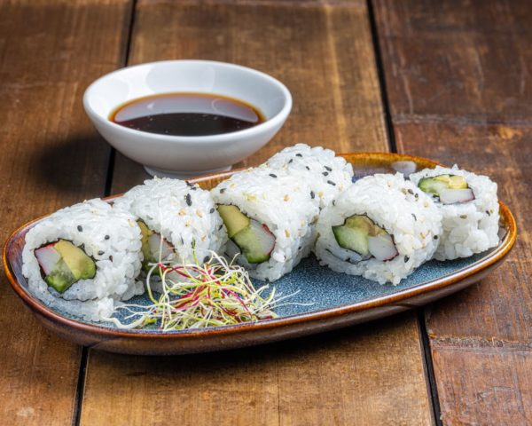 California roll garni de surimi savoureux, tranches d'avocat crémeux et concombre croquant, présenté de manière élégante pour une combinaison fraîche et délicieuse.