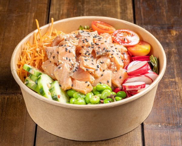 Poké bowl garni de morceaux de saumon frais, accompagnés de fruits et légumes colorés et de riz, présenté dans un bol.