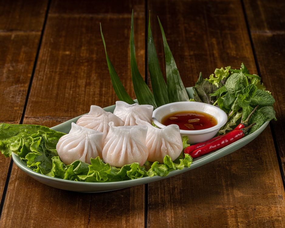 Raviolis à la vapeur garnis de crevettes, servis avec une sauce, produit de Tokyo Sushi