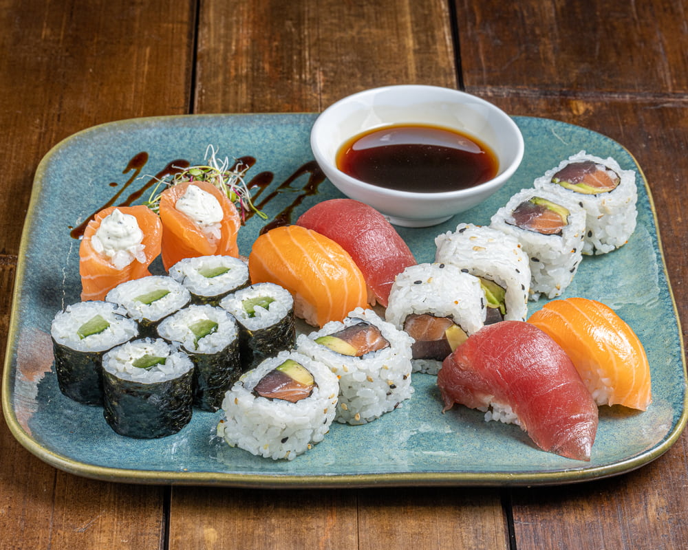 Sushi Box 'Tokyo City' de 18 pièces variées : 6 California au thon, saumon et avocat, 6 makis au concombre et cream cheese, 2 sushis saumon, 2 sushis thon et 2 tulipes au saumon, le tout présenté dans une boîte soignée.
